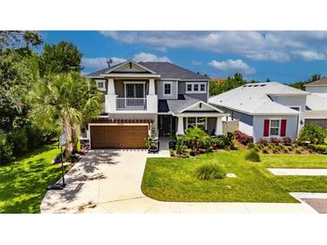 Charming two-story home features a well-manicured lawn, inviting front porch, and attached two-car garage at 10399 Boyette Brook St, Riverview, FL 33569