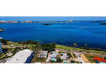 Breathtaking aerial view of waterfront homes, showcasing stunning ocean views and lush tropical landscaping at 1951 Edgewater Dr, Clearwater, FL 33755
