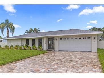 Charming home with a brick driveway, white exterior, and well-maintained landscaping at 1964 Tanglewood Ne Dr, St Petersburg, FL 33702