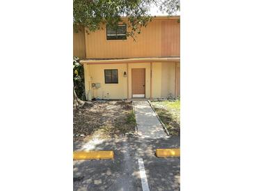 Inviting two-story townhome featuring a charming front entrance with a well-maintained walkway and landscaping at 4003 Oak Limb Ct, Tampa, FL 33614