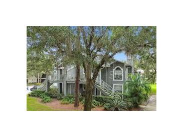 Charming exterior view of a multi-story home with mature trees and landscaping at 11941 Skylake Pl # 11941, Temple Terrace, FL 33617