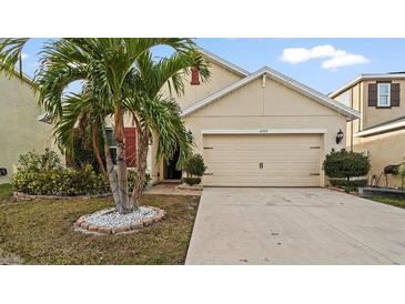 Charming home featuring a well-manicured lawn and two-car garage with a stylish design at 12017 Gillingham Harbor Ln, Gibsonton, FL 33534