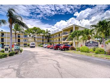 Well maintained three story building with parking and landscaping under a beautiful blue cloudy sky at 14130 Rosemary Ln # 4215, Largo, FL 33774