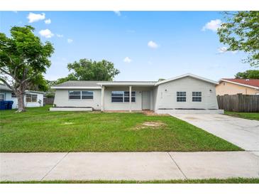 Charming single-story home features a well-maintained lawn and a classic, neutral-toned exterior at 4414 Royal Oak Ln, New Port Richey, FL 34653