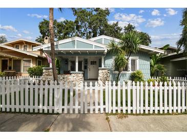 Charming light blue bungalow with a white picket fence and stone accents at 711 S Bungalow Ter, Tampa, FL 33606