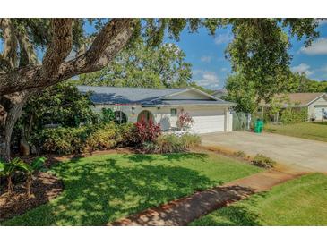 Charming single-story home featuring a lush front yard and a driveway leading to an attached garage at 7699 92Nd St, Seminole, FL 33777