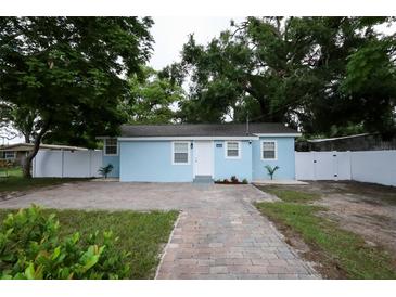 Charming, light blue single-Gathering home with a brick walkway and well-maintained front yard at 8405 N Willow Ave, Tampa, FL 33604
