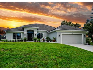 Charming single-story home boasts a well-manicured lawn and inviting curb appeal at sunset at 13045 Irwin Dr, Port Charlotte, FL 33953