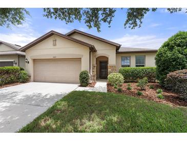Inviting single-story home featuring a well-maintained lawn and a two car garage at 1827 Trillium Blvd, Brooksville, FL 34604