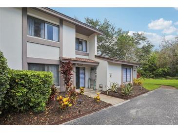 Two-story home with neutral paint, landscaping, and a private walkway leading to the entrance at 1830 Cypress Trace Dr, Safety Harbor, FL 34695