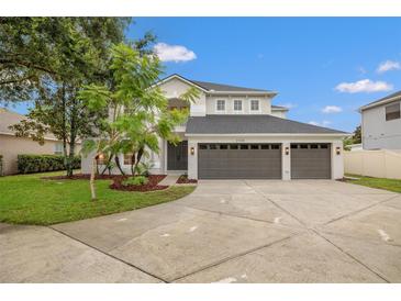 Beautiful two-story home features a three car garage, manicured lawn, and well-maintained landscaping at 21108 Bircholm Ct, Land O Lakes, FL 34637