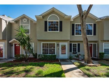 Charming townhome featuring a well-maintained front yard and a welcoming entrance at 2175 Fox Chase Blvd, Palm Harbor, FL 34683