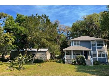 Charming two-story home with a covered porch and a lush green yard at 222 Spring Lake Hwy, Brooksville, FL 34602