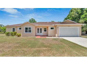 Charming single story home featuring a manicured lawn and an attached two car garage at 2627 Hancock St, Plant City, FL 33563