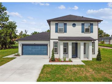 Charming two-story home with blue shutters, a well-manicured lawn and a two car garage at 301 S Daniels St, Plant City, FL 33563