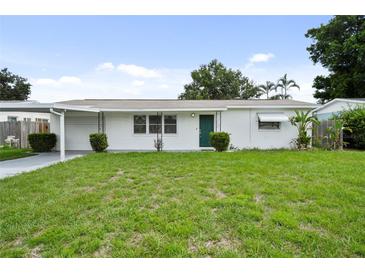 Charming single-story home with fresh exterior paint, a well-maintained lawn, and carport at 5627 57Th N Ave, St Petersburg, FL 33709