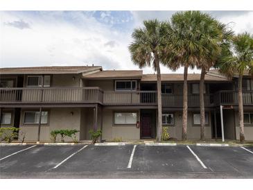 Two story condo building featuring palm trees, reserved parking and a welcoming facade at 6332 Newtown Cir # 32B2, Tampa, FL 33615