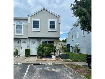 Charming townhome featuring a modern facade, well-maintained landscaping, and reserved parking at 6781 121St Ave # H, Largo, FL 33773