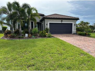 Charming single-story home featuring a tile roof, well-manicured lawn, and a brick driveway at 7683 Summerland Cv, Lakewood Ranch, FL 34202