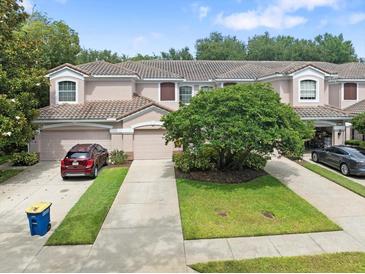 Charming townhome with a tile roof, attached garage, and a well-manicured lawn at 897 Lantern Way, Clearwater, FL 33765