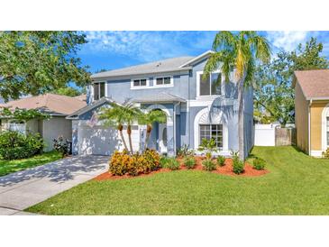 Charming two-story home with a well-manicured lawn and lovely landscaping at 1734 Mapleleaf Blvd, Oldsmar, FL 34677