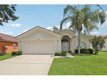 Charming single-story home with a well-maintained lawn, two car garage, and a beautiful palm tree at 2625 Brookville Dr, Valrico, FL 33596