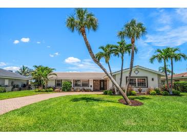 Charming single-story home with lush lawn, beautiful palms and a brick driveway at 4754 Overlook Ne Dr, St Petersburg, FL 33703