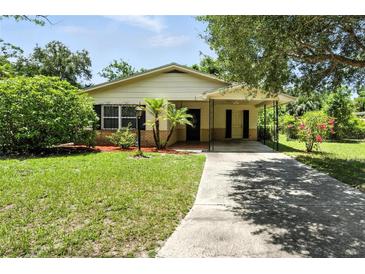 Charming single-story home with mature landscaping and a covered carport providing shade and curb appeal at 1116 W Kirby St, Tampa, FL 33604
