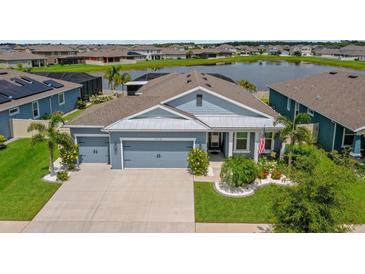 Charming single-story home with lush landscaping, a two-car garage, and a serene waterfront view at 11714 Tetrafin Dr, Riverview, FL 33579