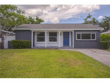 Charming single-story home with a blue front door, landscaped yard, and a well-maintained lawn at 1882 Maryland Ne Ave, St Petersburg, FL 33703