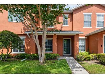 Charming two-story townhome with a well-maintained lawn, shrubs, and shade tree framing the front entrance at 2066 Sun Down Dr, Clearwater, FL 33763