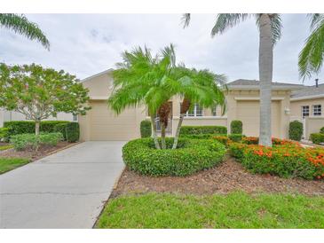 Charming single-story home featuring lush landscaping, mature trees, and a two-car garage at 2292 Sifield Greens Way # 59, Sun City Center, FL 33573