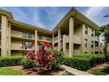 Attractive condo building featuring well-maintained landscaping and multi-level balconies at 2690 Coral Landings Blvd # 122, Palm Harbor, FL 34684