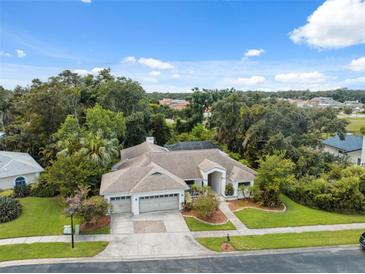 Expansive home with manicured lawn, mature trees, three-car garage and screened in pool at 3037 Crest Dr, Clearwater, FL 33759