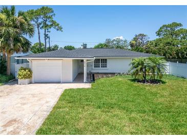 Charming single-story home with a well-manicured lawn, a stone driveway, and lush landscaping at 4518 Helena Ne St, St Petersburg, FL 33703