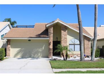 Charming single-story home with a two-car garage and a well-manicured front lawn at 5581 Greyston St, Palm Harbor, FL 34685