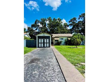 Charming single-story home featuring an attached garage and a well-maintained lawn, with mature trees in the background at 3135 33Rd N Ave, St Petersburg, FL 33713