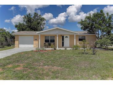Charming single-story home with a manicured front yard, inviting porch, and attached one-car garage at 3707 Cambridge St, New Port Richey, FL 34652