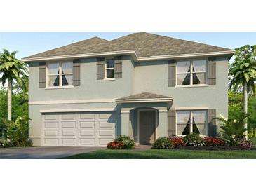 Charming two-story home with a two car garage, complemented by tasteful landscaping and a well-manicured lawn at 7710 Wheat Stone Dr, Zephyrhills, FL 33540