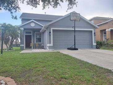 Charming single-story home with a gray exterior, well-manicured lawn, and a two-car garage at 10109 36Th E Ct, Parrish, FL 34219