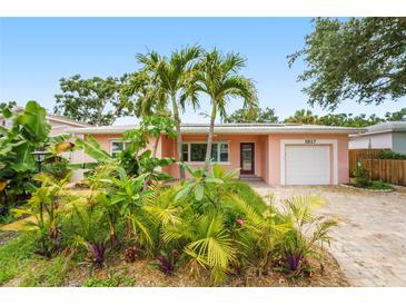 Charming single-story home with a lush front yard, palm trees, brick driveway, and a one-car garage at 1517 60Th S St, Gulfport, FL 33707