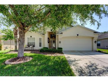 Charming single-story home featuring a well-manicured lawn and a spacious two-car garage at 4522 Lisette Cir, Brooksville, FL 34604