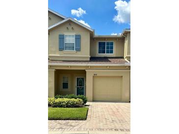 Charming two-story townhouse featuring a one car garage and well-maintained landscaping at 9212 River Rock Ln, Riverview, FL 33578