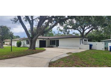 Charming home featuring a well-maintained lawn, and ample parking space with mature shade trees at 1027 Fountainhead Dr, Largo, FL 33770