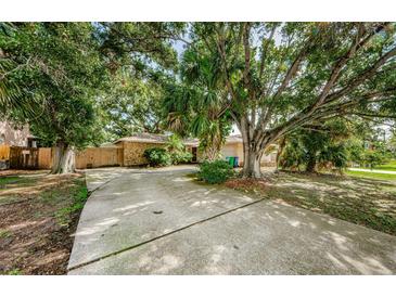A long driveway leads to this charming home with stone accents and mature trees at 11783 102Nd Ave, Largo, FL 33778