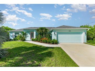 Charming single-story home featuring a manicured lawn, vibrant landscaping, and an attached two-car garage at 13116 Marathon Blvd, Port Charlotte, FL 33981