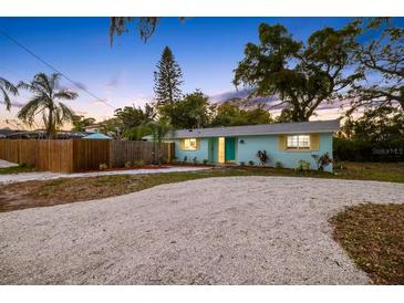 Charming single story home with a well kept lawn, wooden fence, and inviting landscaping at 201 South St, Palm Harbor, FL 34683