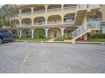 Condominium complex featuring covered parking, multiple floors, and exterior stairway at 2222 Norwegian Dr # 16, Clearwater, FL 33763