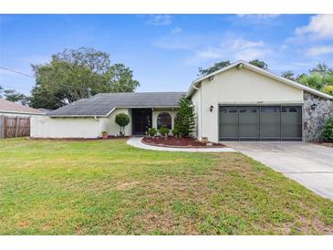 Charming single-story home featuring a well-maintained lawn and a two-car garage at 2319 Canfield Dr, Spring Hill, FL 34609
