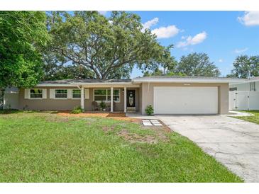 Charming single-story home with a well-manicured lawn, mature trees, and an attached two-car garage at 2353 Eastwood Dr, Clearwater, FL 33765